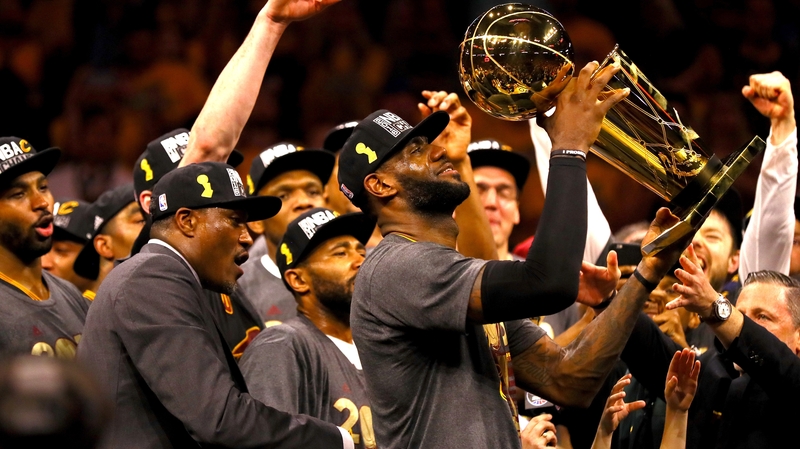 LeBron James #23 of the Cleveland Cavaliers holds the Larry O'Brien Championship Trophy