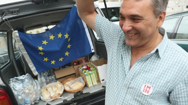 A man distributes snacks under an EU flag outside a polling station in Gibraltar