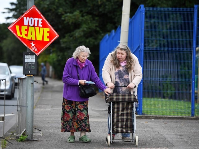 Two women make their way towards a polling station in Belfast