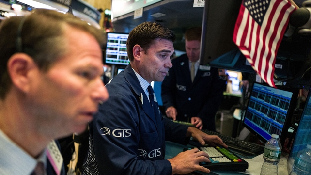 Traders and financial professionals work on the floor of the New York Stock Exchange as they await the final result