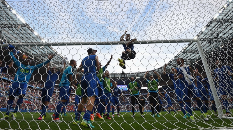 Gianluigi Buffon hangs from the crossbar as he and his team-mates celebrate their victory