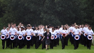 Young people holding flowers and wreaths take part in the memorial ceremony