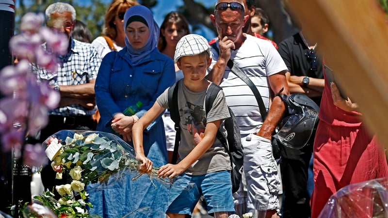People gather in front of a makeshift memorial on the 'Promenade des Anglais' in Nice