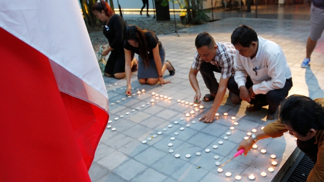 Cambodians light candles during a ceremony at French Institute in Phnom Penh