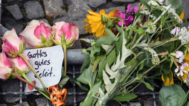Flowers and a note that reads 'Gottes gutes Geleit' (God's safe passage) were placed in front of the French embassy in Berlin