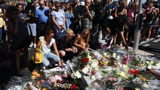 People lay flowers for the victims of the attack on the Promenade des Anglais