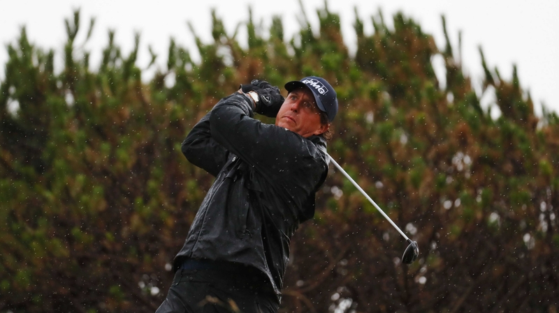 Mickelson hits a shot in full rain gear in terrible conditions at Troon on Friday