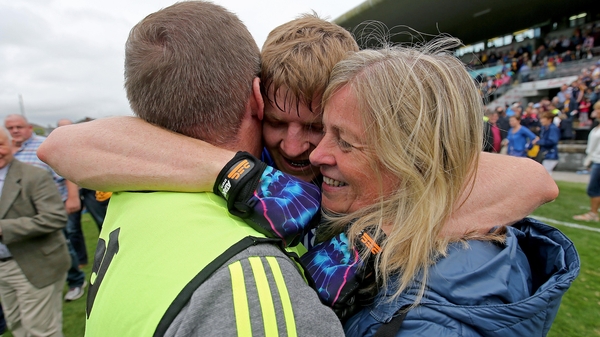 Podge Collins (centre) celebrates with his father and mother