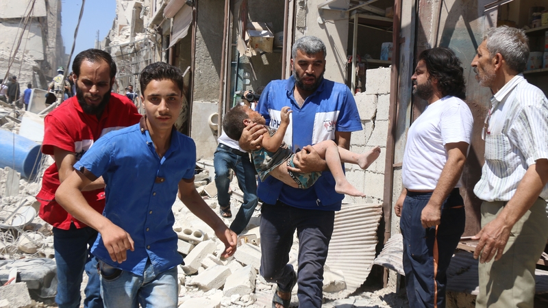 A civil defence volunteer carries a wounded child following a reported air strike in Aleppo