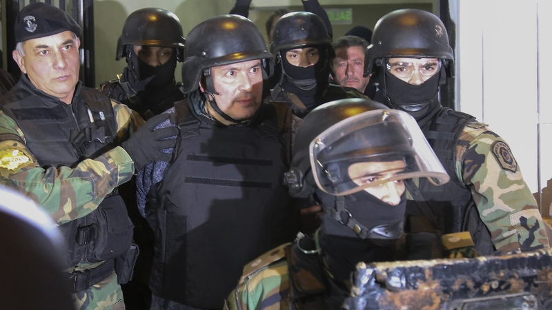 Jose Lopez (C) is taken into custody after his arrest last month