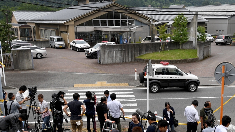 Journalists gather at the main gate of the Tsukui Yamayuri En care centre