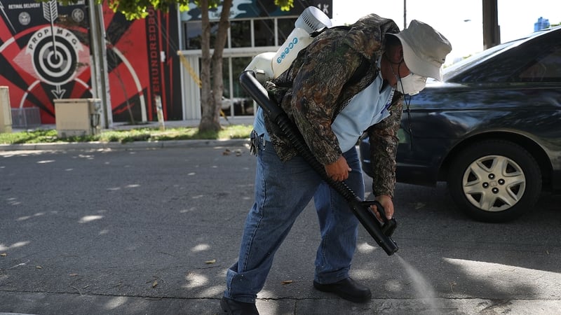 A mosquito control inspector sprays pesticide in a Miami neighbourhood