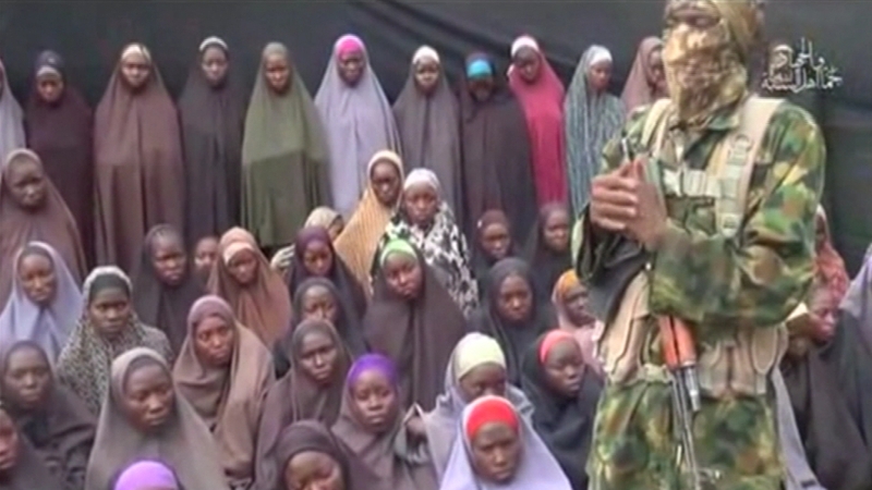 In the video published on social media, a masked man stands beside dozens of girls