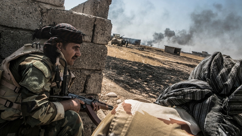 Peshmerga forces take cover as they begin an operation to liberate several villages currently under the control of IS southeast of Mosul, Iraq