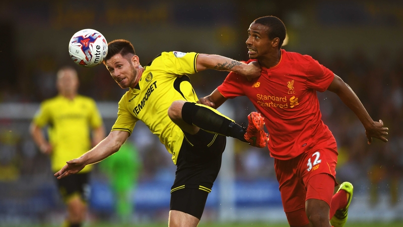 Calum Butcher of Burton Albion is challenged by Liverpool's Joel Matip