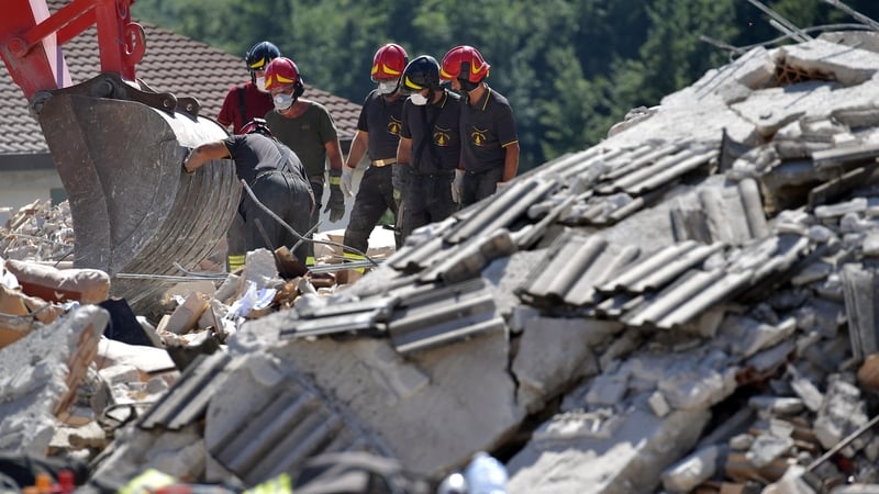 Rescue workers search through the rubble of a destroyed building for survivors in Amatrice