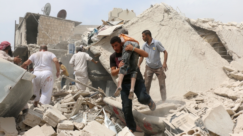 A man carries a wounded child after a bomb attack in Aleppo