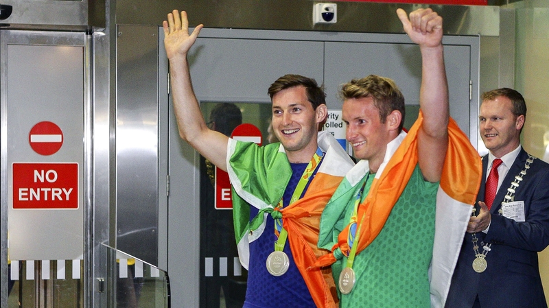 Paul and Gary O'Donovan wave to the crowd at Cork airport last night