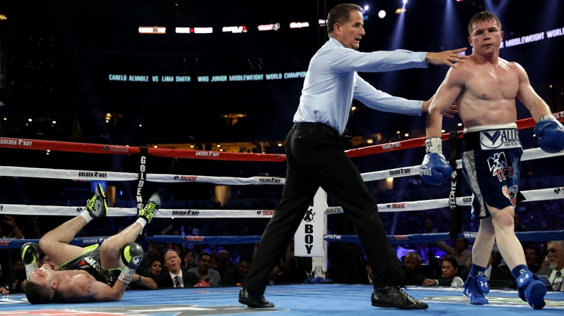 Canelo Alvarez (R) is shown to his corner after knocking down Liam Smith