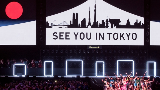 Dancers perform in front of a sign that says 'See you in Tokyo', where the games are due to be held in 2020