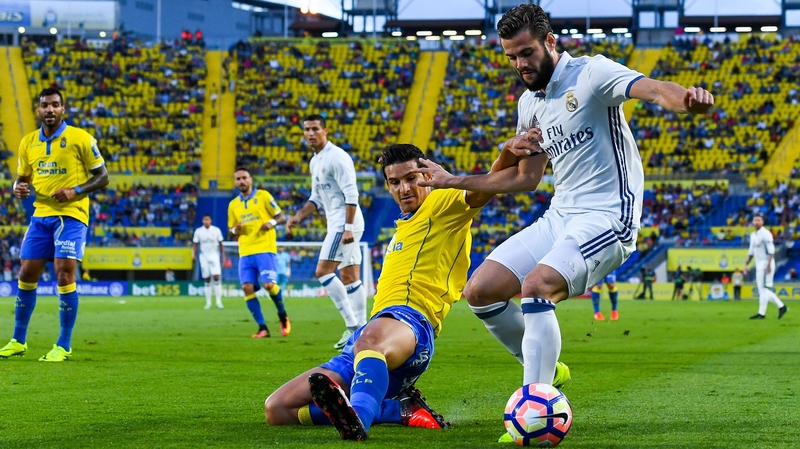 Nacho Fernandez of Real Madrid CF is tackled by Vicente Gomez of UD Las Palmas