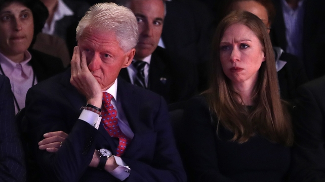 Husband and former US president Bill Clinton and daughter, Chelsea Clinton, listen as Democratic nominee Hillary Clinton speaks during the debate