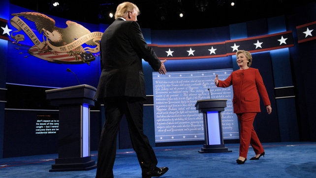 Donald Trump and Hillary Clinton greet each other on stage at the university in Hempstead, New York