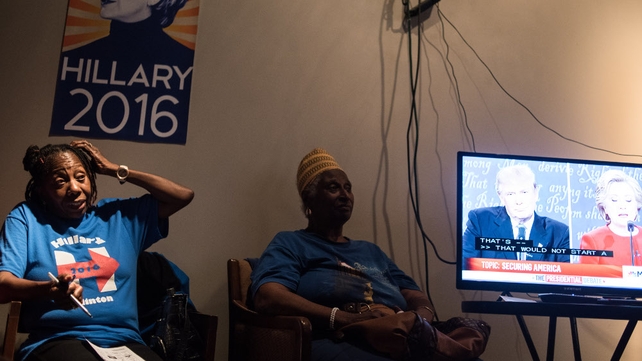 Women watch the debate at the South Carolina Hillary Clinton campaign headquarters