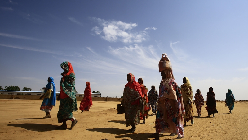 Women walk at the Abu Shouk camp for Internally Displaced People, near North Darfur's state capital