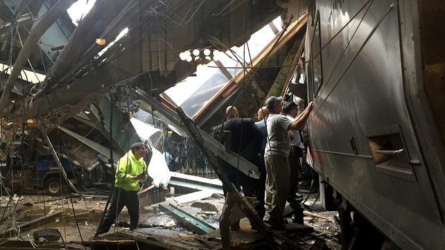 Train personnel survey the NJ Transit train that crashed into the platform