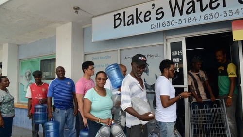 People wait in line to refill water bottles in preparation for Hurricane Matthew in Kingston, Jamaica