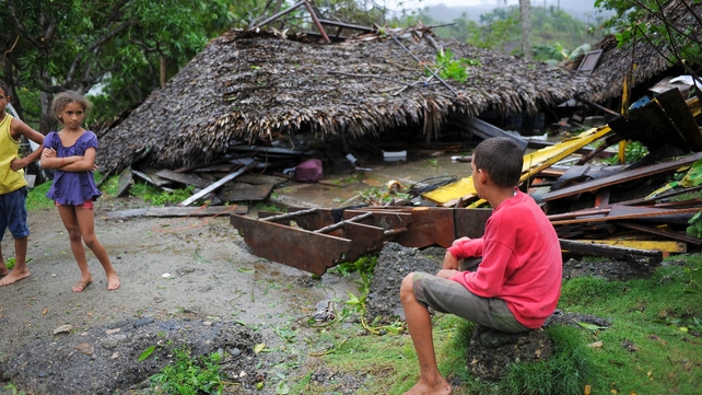 Children are seen before damaged property in the Carbonera community of Guantanamo, Cuba