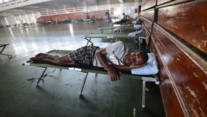 A man sleeps on a cot inside the National Arena, the main disaster shelter in Kingston, Jamaica