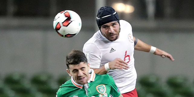 Murtaz Daushvili of Georgia, wearing protective headgear, beats Robbie Brady in the air