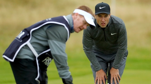 Fisher lines up a putt on the 17th with the help of his caddie on the Old Course at St Andrews