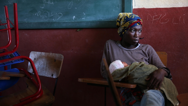 A woman with her baby remains in the shelter of the Lyceum Jean Claudy Muzo , in Les Cayes