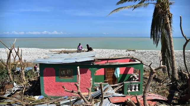 Members of a family repair their home damaged by Hurricane Matthew in Gomier