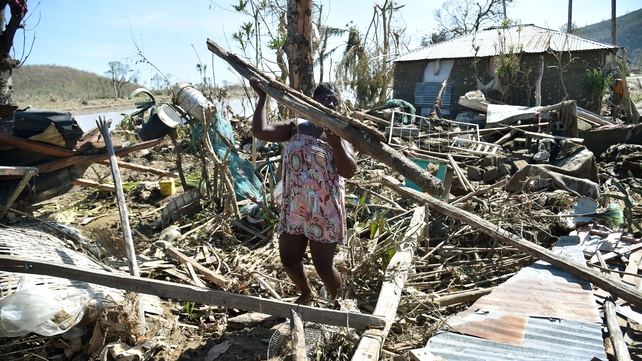 Sasa, 25, takes the remains of her house destroyed by Hurricane Matthew, to build another in a nearby field in Jeremie