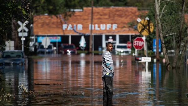 Austin Snowten stands in a flooded street caused by remnants of Hurricane Matthew in Fair Bluff, North Carolina