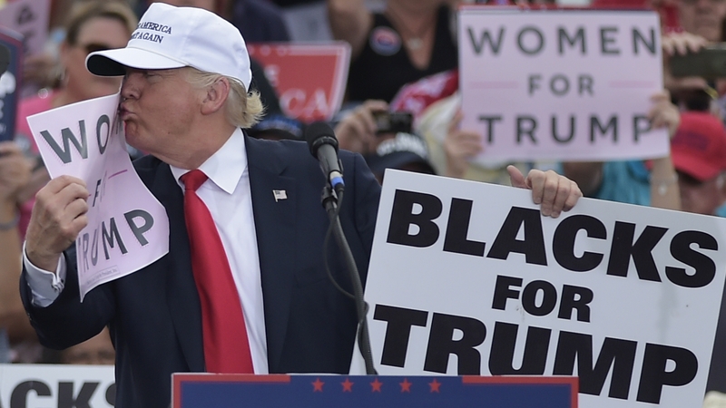 Donald Trump kisses a sign saying 'Women for Trump'