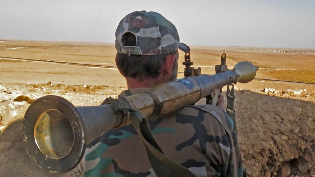 A Syrian government forces fighter holds a rocket-propelled grenade on the outskirts of Damascus as they reinforce their presence on the highway between the capital and Aleppo