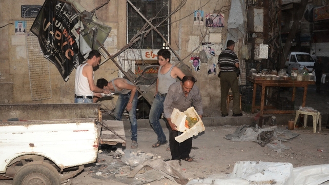 Syrians inspect the damage caused by an artillery attack in the al-Jamiliyeh neighbourhood in the government-controlled side of Aleppo