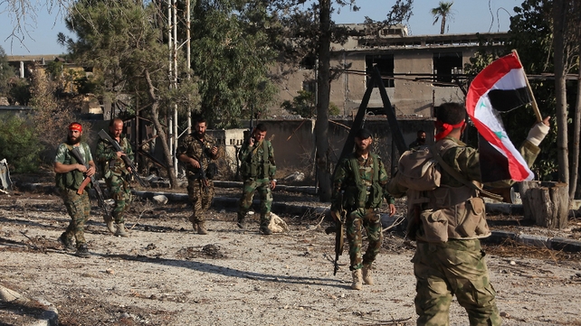 Syrian pro-government soldiers patrol the Uwaija neighbourhood as they advance in Aleppo's rebel-held areas