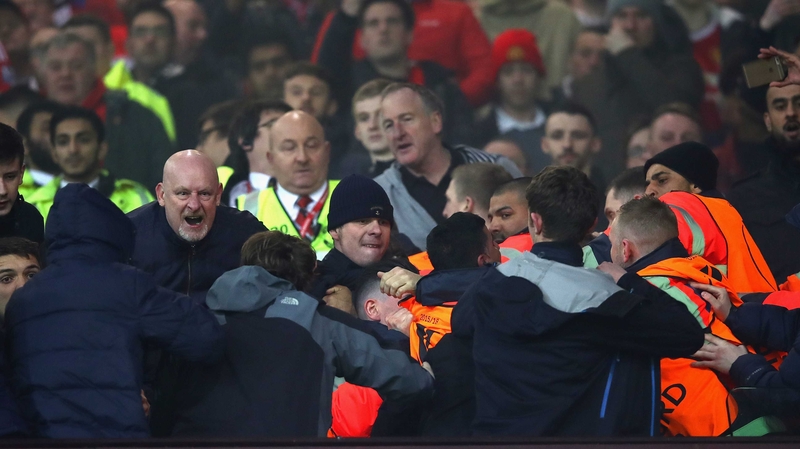 Fans are restrained by stewards after the Europa League clash between Manchester United and Liverpool at Old Trafford last March