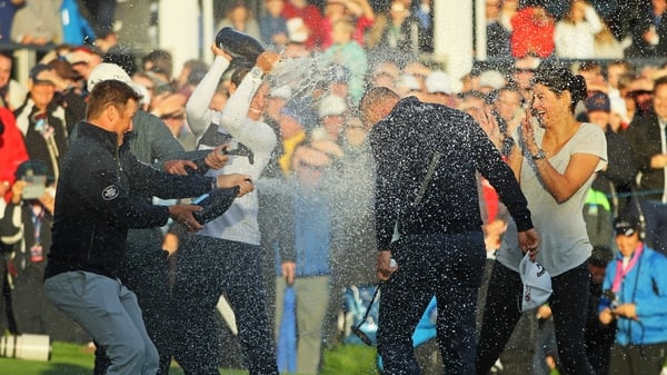 Alex Noren is soaked in champagne on the 18th green