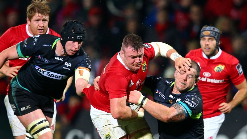 Munster's Dave Kilcoyne is tackled by Paul James of Ospreys