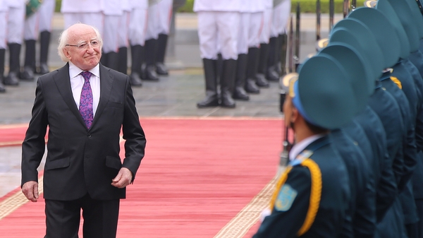 President Michael D Higgins reviews an honor guard during a welcoming ceremony at the Presidential Palace in Hanoi