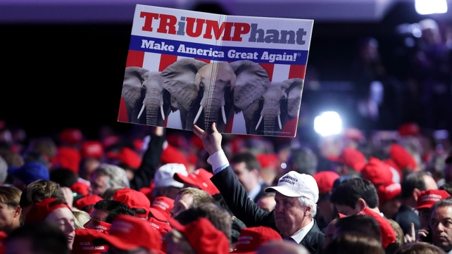 A supporter holds up a sign in support of Donald Trump during the election night event