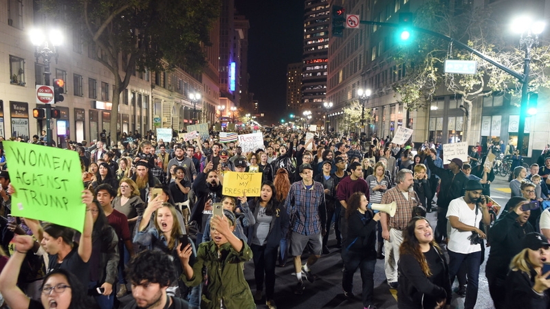 People march and shout during an anti-Trump protest in Oakland, California