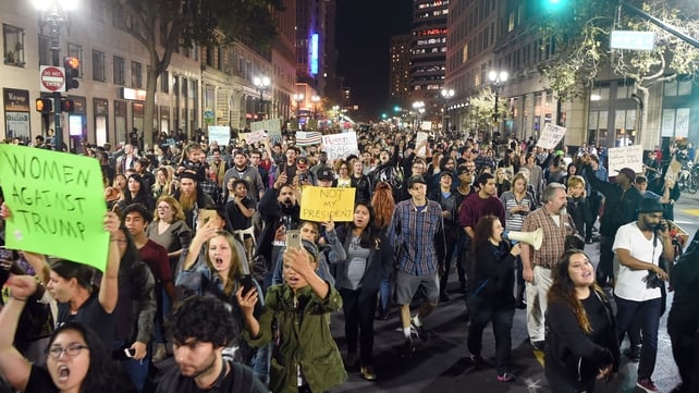 People march and shout during an anti-Trump protest in Oakland, California